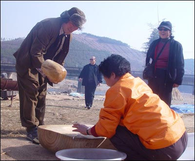 인절미를 빚기위해 떡메를 치고 있는 오기배 촌장. 